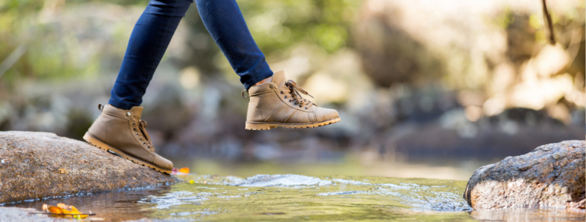 Person stepping from one side of a creek to another